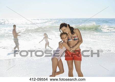 Mother and daughter hugging on beach View Large Photo Image Picture - Mother and daughter hugging on beach. Fotosearch