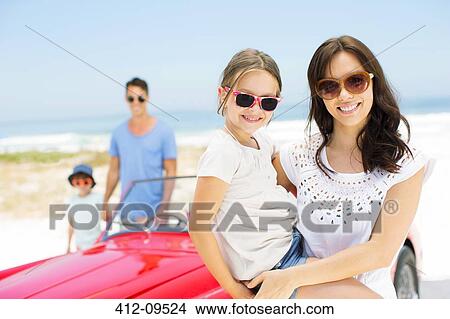 Mother and daughter smiling by convertible on beach View Large Photo Image Picture - Mother and daughter smiling by convertible on beach. Fotosearch