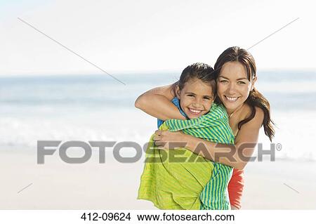 Mother wrapping daughter in towel on beach View Large Photo Image Picture - Mother wrapping daughter in towel on beach. Fotosearch