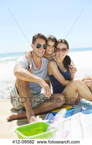 Portrait of smiling family hugging on beach View Large Photo Image Stock Image - Portrait of smiling family hugging on beach. Fotosearch