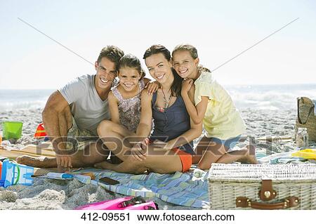 Portrait of smiling family on blanket at beach View Large Photo Image Stock Image - Portrait of smiling family on blanket at beach. Fotosearch