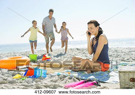 Stock Photo - Woman talking on cell phone at beach. Fotosearch