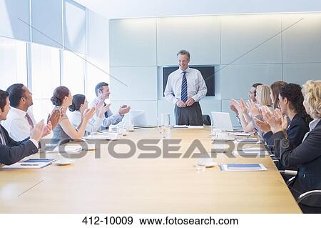 Business people applauding colleague in meeting View Large Photo Image Stock Photo - Business people applauding colleague in meeting. Fotosearch