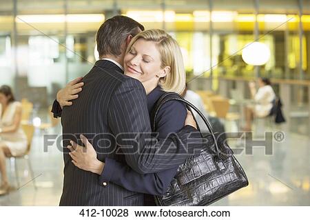 Stock Photo - Business people hugging in office. Fotosearch