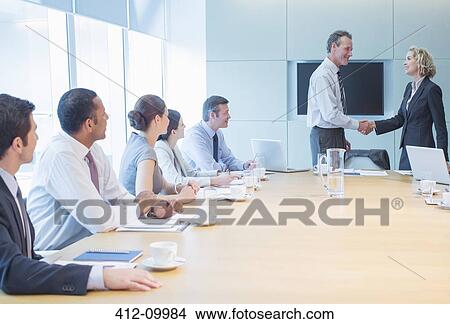 Picture - Business people shaking hands in office. Fotosearch