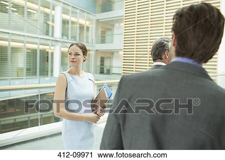 Business people standing in office View Large Photo Image Stock Image - Business people standing in office. Fotosearch