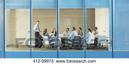 Stock Image - Business people talking in conference room. Fotosearch