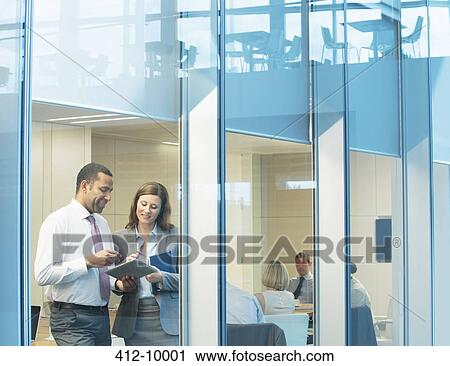 Stock Image - Business people talking in conference room. Fotosearch