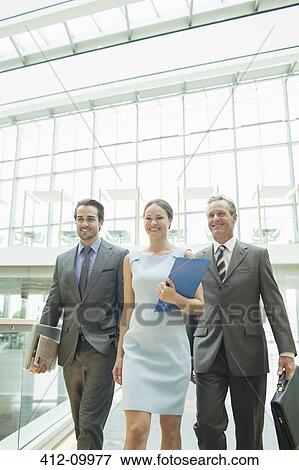 Business people walking in office View Large Photo Image Stock Photo - Business people walking in office. Fotosearch