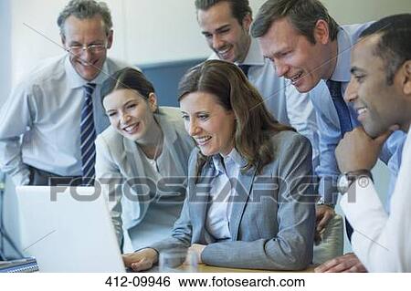 Stock Photograph - Business people working at laptop in office. Fotosearch