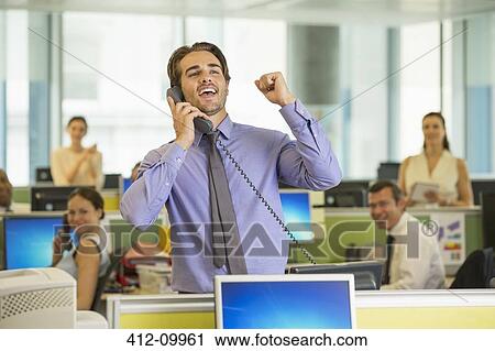 Stock Image - Businessman cheering in office. Fotosearch