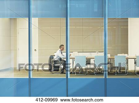 Businessman sitting in conference room View Large Photo Image Stock Photo - Businessman sitting in conference room. Fotosearch
