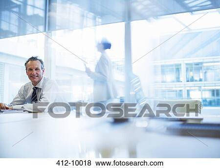 Businessman sitting in conference room View Large Photo Image Stock Photo - Businessman sitting in conference room. Fotosearch