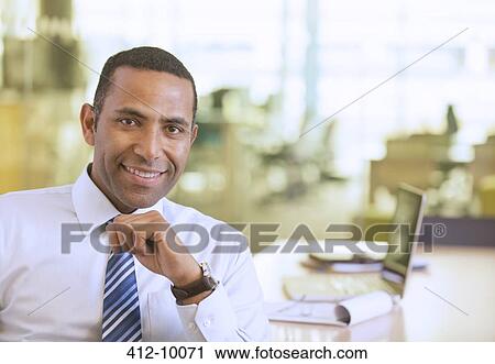 Businessman smiling in office View Large Photo Image Stock Image - Businessman smiling in office. Fotosearch