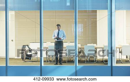 Businessman standing in conference room View Large Photo Image Stock Image - Businessman standing in conference room. Fotosearch