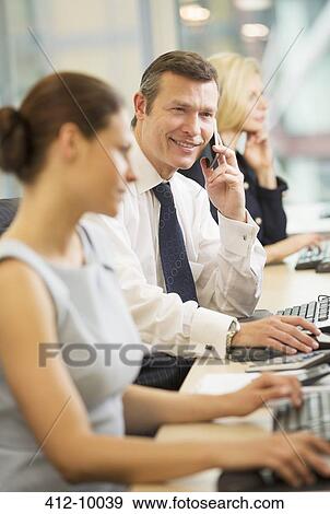 Businessman talking on cell phone in meeting View Large Photo Image Stock Photo - Businessman talking on cell phone in meeting. Fotosearch