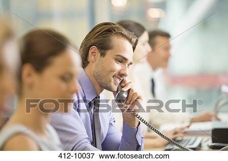 Businessman talking on telephone in office View Large Photo Image Stock Photo - Businessman talking on telephone in office. Fotosearch