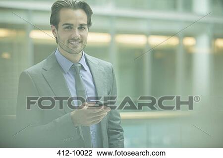 Businessman using cell phone in office View Large Photo Image Stock Image - Businessman using cell phone in office. Fotosearch