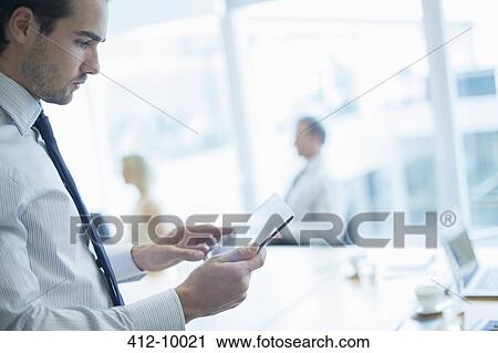 Businessman using digital tablet in conference room View Large Photo Image Stock Image - Businessman using digital tablet in conference room. Fotosearch
