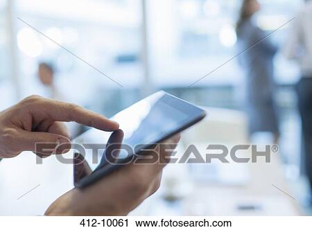Businessman using digital tablet in office View Large Photo Image Stock Image - Businessman using digital tablet in office. Fotosearch
