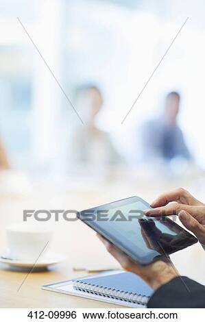 Stock Photograph - Businessman using digital tablet in meeting. Fotosearch