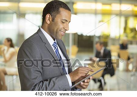 Stock Photograph - Businessman using digital tablet in office. Fotosearch