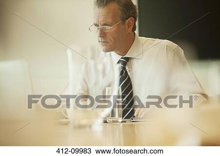 Stock Image - Businessman using laptop in office. Fotosearch