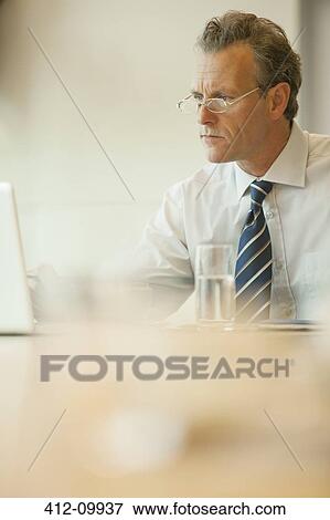 Businessman working at desk View Large Photo Image Stock Photo - Businessman working at desk. Fotosearch
