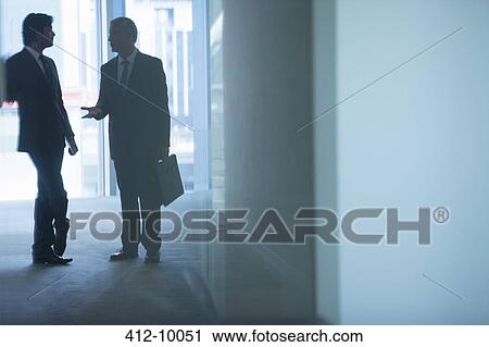 Businessmen talking in office corridor View Large Photo Image Stock Image - Businessmen talking in office corridor. Fotosearch