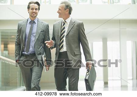 Stock Photo - Businessmen talking in office lobby. Fotosearch