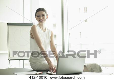 Businesswoman smiling at desk View Large Photo Image Stock Image - Businesswoman smiling at desk. Fotosearch