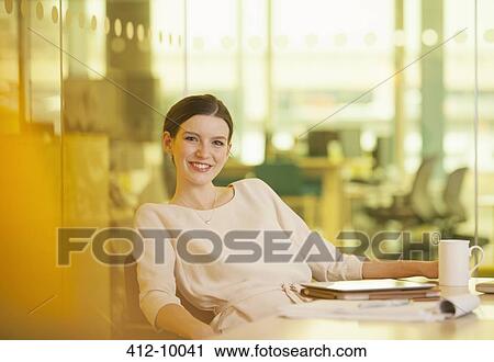 Businesswoman smiling in office View Large Photo Image Stock Image - Businesswoman smiling in office. Fotosearch