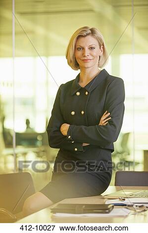 Businesswoman smiling in office View Large Photo Image Stock Photo - Businesswoman smiling in office. Fotosearch