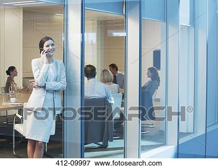 Businesswoman talking on cell phone in meeting View Large Photo Image Stock Photo - Businesswoman talking on cell phone in meeting. Fotosearch