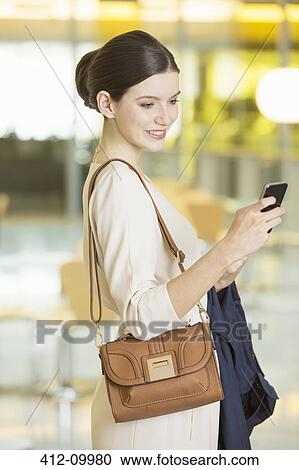 Businesswoman using cell phone in office View Large Photo Image Stock Image - Businesswoman using cell phone in office. Fotosearch