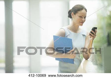 Stock Photo - Businesswoman using cell phone. Fotosearch