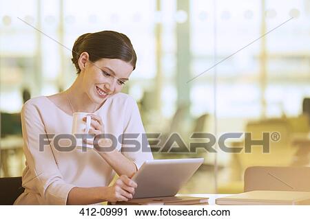 Businesswoman using digital tablet in office View Large Photo Image Stock Image - Businesswoman using digital tablet in office. Fotosearch