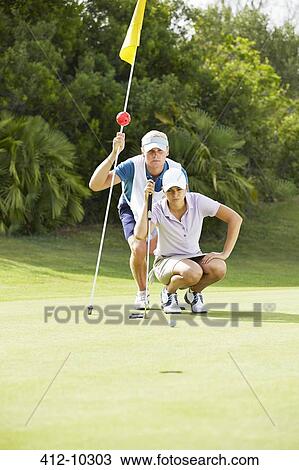 Caddy and golfer preparing to putt View Large Photo Image Stock Image - Caddy and golfer preparing to putt. Fotosearch