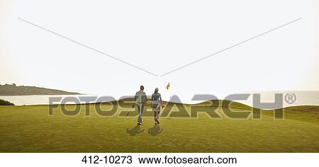 Couple playing golf on course View Large Photo Image Stock Image - Couple playing golf on course. Fotosearch