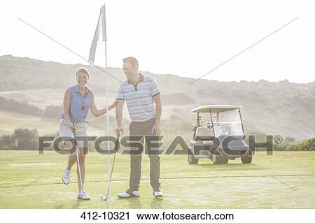 Stock Image - Couple playing golf on course. Fotosearch