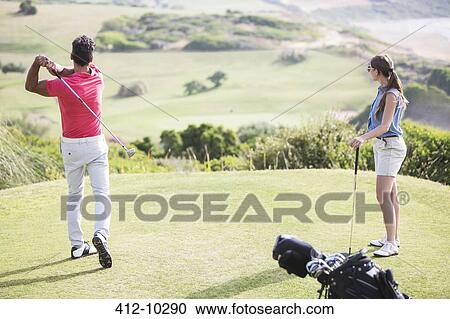Couple teeing off on golf course View Large Photo Image Stock Image - Couple teeing off on golf course. Fotosearch