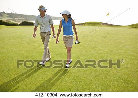 Couple walking on golf course View Large Photo Image Picture - Couple walking on golf course. Fotosearch