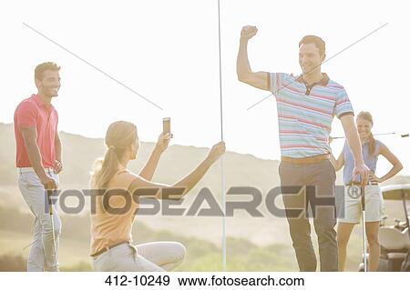 Friends cheering on golf course View Large Photo Image Stock Photo - Friends cheering on golf course. Fotosearch