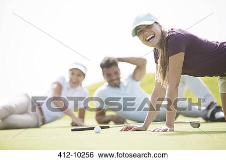 Friends laying and laughing on golf course View Large Photo Image Stock Photograph - Friends laying and laughing on golf course. Fotosearch