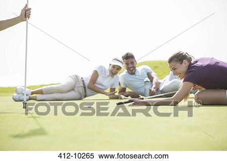 Friends laying on golf course View Large Photo Image Stock Photography - Friends laying on golf course. Fotosearch