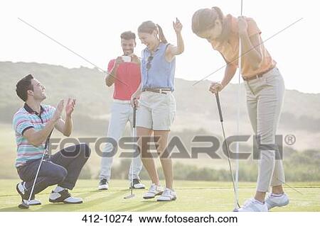Friends playing golf on course View Large Photo Image Picture - Friends playing golf on course. Fotosearch