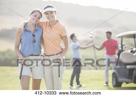 Friends playing golf on course View Large Photo Image Stock Image - Friends playing golf on course. Fotosearch