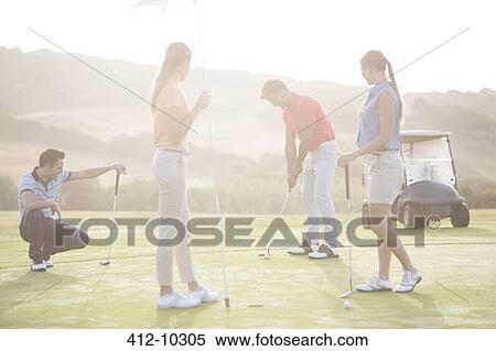 Friends playing golf on course View Large Photo Image Stock Photography - Friends playing golf on course. Fotosearch