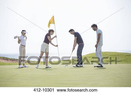 Friends putting on golf course View Large Photo Image Stock Image - Friends putting on golf course. Fotosearch