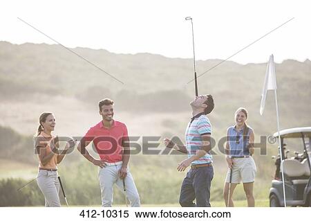 Friends watching man balance golf club on nose View Large Photo Image Stock Photography - Friends watching man balance golf club on nose. Fotosearch